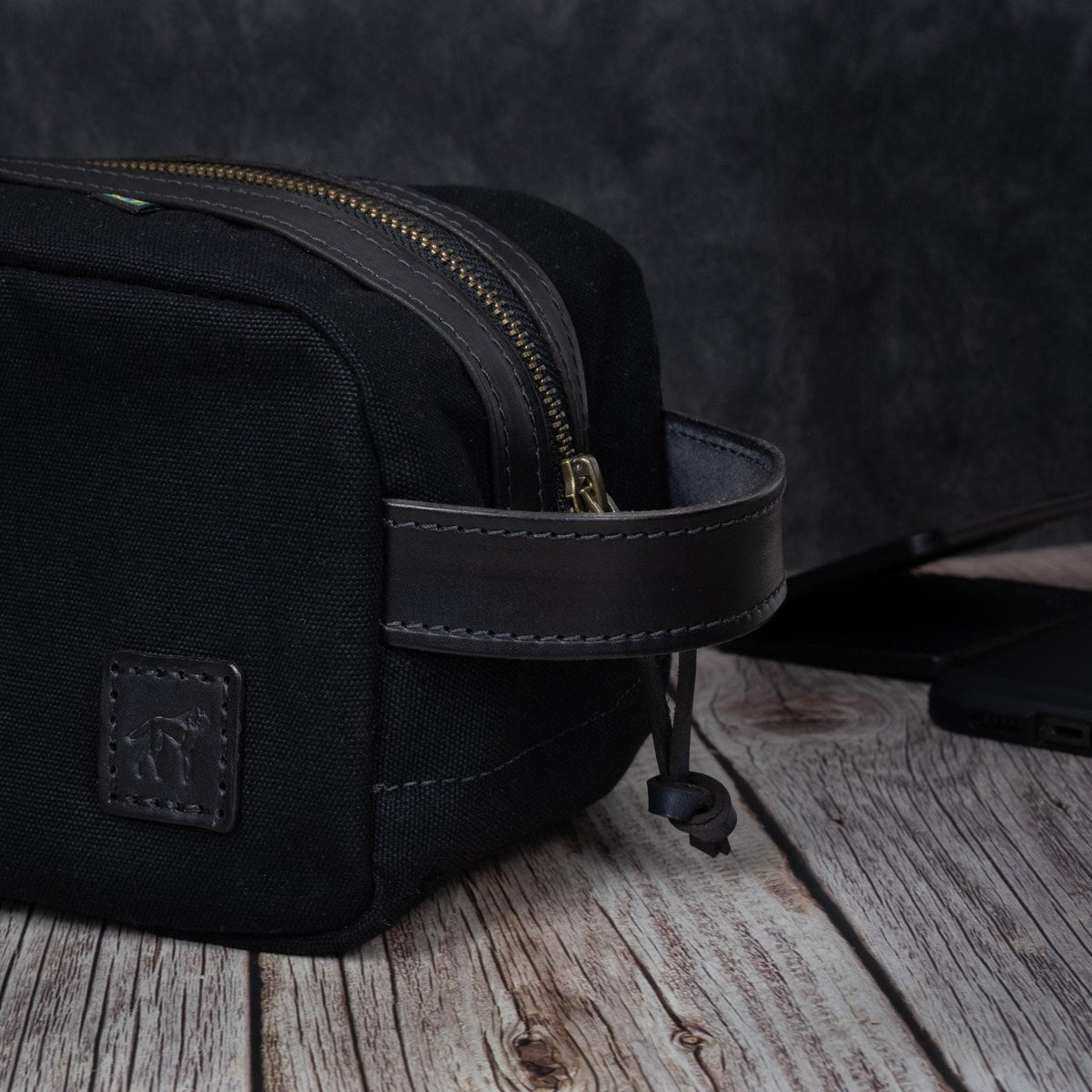 Necessaire Lona Encerada e Couro Preta, still sobre superfície neutra – DANTE Capelli