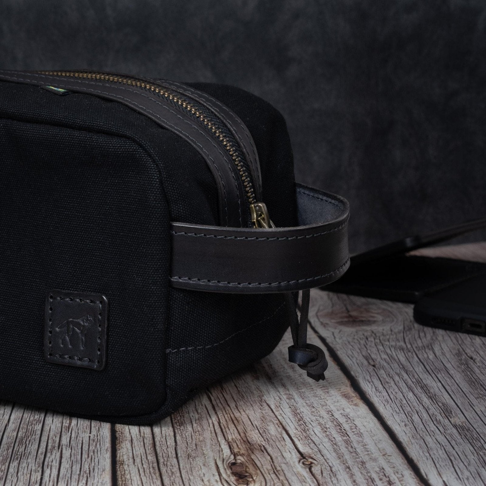 Necessaire Lona Encerada e Couro Preta, still sobre superfície neutra – DANTE Capelli